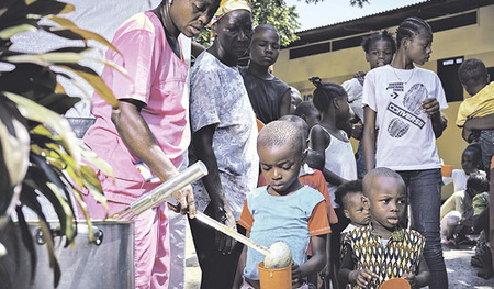 Schwester Scolastique (links) bei der Ausgabe des nahrhaften Breis an unterernährte Kinder