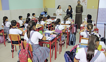 Der Franziskaner P. Andreas Holl aus Enns (rechts hinten) in einer Schulklasse. Er war lange Zeit in Südamerika Missionar und hat Andreas Reumayr begleitet.       
