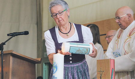 Theresia Hartl, Pfarrgemeinderatsobfrau der Pfarre St. Georgen bei Obernberg, entzündet an der Dekanatskerze die Pfarrkerze.  