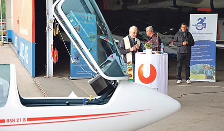 Friedrich Lenhart (mit Stola), Kurat in der Pfarre Linz Mitte, hat das Schulungsflugzeug für beeinträchtigte Menschen (im Vordergrund) gesegnet.    