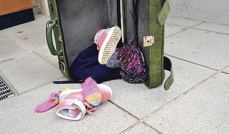 Ein spärlich gefüllter Koffer als Symbol für Flucht.  