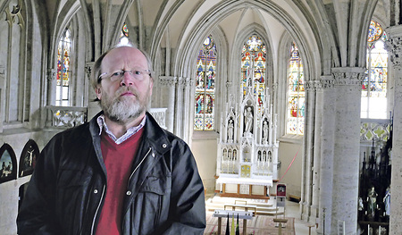 Der Grafiker und Mitarbeiter in der Pfarre Horst Bach-ofner am Chor der Pfarrkirche Bad Hall.   
