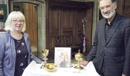 Mit Sicherheitsabstand und einem Lächeln übergibt Dompfarrer Max Strasser das Handbuch an Regina Fürlinger.