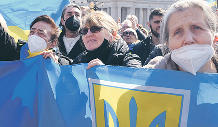 Menschen halten die gelb-blaue Fahnen der Ukraine in den Händen, während des Angelus-Gebetes mit Papst Franziskus. 