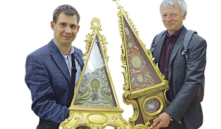 Pfarrer Franz Strasser (rechts) und der Kunststudent Sebastian Mitterbauer mit Reliquiaren in Pyramidenform, die auf dem Altar der Pfarre Altheim stehen.  
