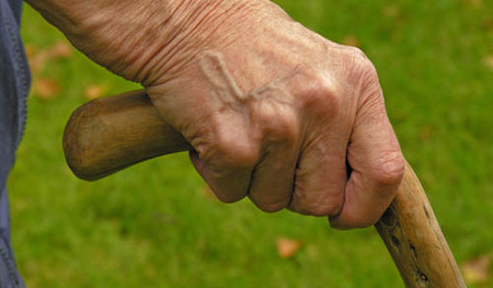 MR Hand von einer alten Frau st?tzt sich an einem knorrigen Stock aus Holz - MR hand of an old woman holding a knobbed old wooden cane