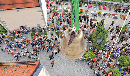 Ein fast symbolisches Bild: die Pfarre unter dem Schirm der Glocke (links)