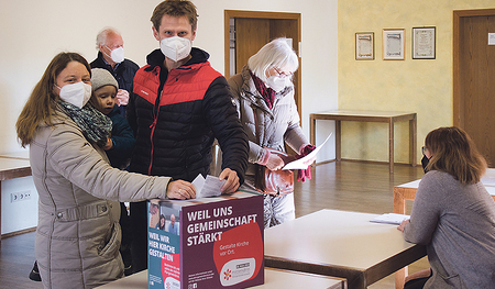 Eine junge Familie bei der Wahl in der Stadtpfarre Braunau.  