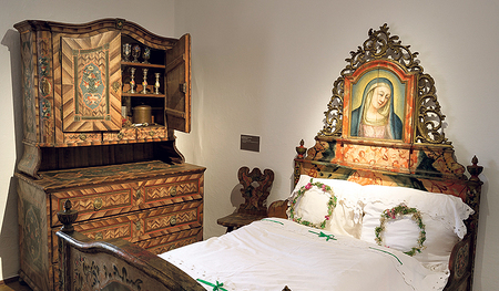 Ein Hochzeitsbett und ein Vogerl, das an die Hl.-Geist-Taube erinnert. 