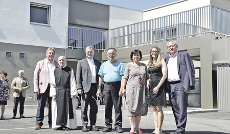 Vor dem Wohnkomplex (v. l. n. r.): Bgm. Mario Mühlböck, Gottfried Hemmelmayr, Stift Wilhering, Bischof Manfred Scheuer, Bewohner Hubert, Sozial-Landesrätin Birgit Gerstorfer, Sandra Wiesinger, GF Institut Hartheim, Landtagsabgeordneter Wolfgang Stane