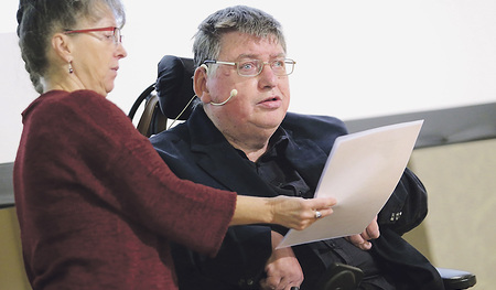 Alfred Prantl, Obmann der Vereinigung der Interessenvertretungen der Menschen mit Beeinträchtigung in OÖ. Eine „Persönliche Assistentin“ unterstützt ihn bei einem Vortrag.  