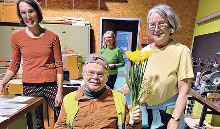 Das Team des Repair-Cafés gratulierte Josef Hagen­auer, dem 100. Besucher, mit einer Süßigkeit und einem Blumenstrauß.  
