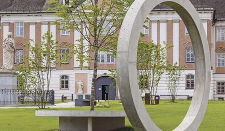 Der Stiftshof wird von Wilhelm Scherübels Betonringen geprägt. Ein Baum, um den eine große Tischplatte betoniert ist, zeigt das innige Verhältnis von Kultur und Natur.  