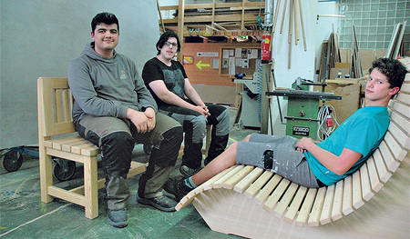 Adis Ibrahimovic, Tobias Scheutz und Tobias Casapiccola (von links) präsentieren einen Teil des „Trüföbankls“. Sie gehören zum Lehrlingsteam, das die Sitzgelegenheiten tischlert. Nur für das Foto haben sie die Maske weggelassen.  
