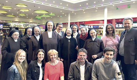 Pfarrer Heinz Purrer (2. von rechts, kniend) und Bürgermeister Mair (rechts) mit Kinobesucher/innen und -besuchern.  