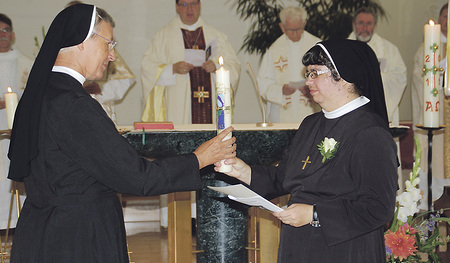 Provinzoberin Sr. Gabriele Schachinger (links) überreicht Sr. Doris Maria die Professkerze zur Tauferneuerung in der Profess.   