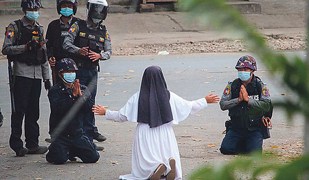 Auf Knien bittet die katholische Ordensfrau Ann Rose Nu Tawng bewaffnete Polizisten in Myanmar, keine Gewalt gegen Demonstranten anzuwenden. 