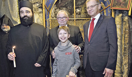 Das Friedenslichtkind Niklas Lehner strahlt. Der griechisch-orthodoxe Mönch Cyprianus hat ihm soeben die Laterne entzündet, die ihn bis Weihnachten ständig begleiten wird. Günther Hartl vom ORF Oberösterreich steht Niklas in den kommenden Wochen bei 